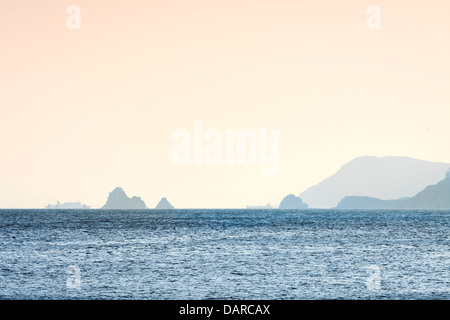 Zwei Schiffe segeln am Horizont hinter den Oryukdo Inseln bei Sonnenuntergang in Busan, Südkorea. Von Haeundae Strand gesehen. Stockfoto