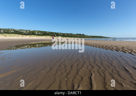 Stadt von Harlech, Wales. Malerische Aussicht auf eine einsame Dame Walker auf dem südlichen Abschnitt von Harlech Beach. Stockfoto