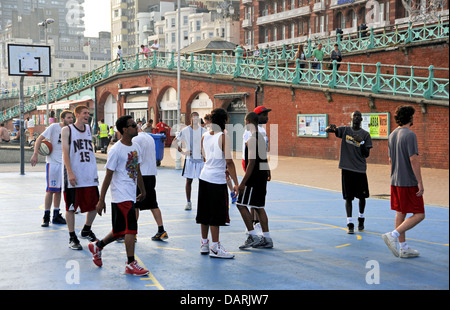 Junge Männer verschiedener Nationalitäten und Rassen spielen Basketball auf Brighton Seafront UK Stockfoto