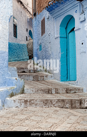 Mann trägt Djellaba und zu Fuß durch die Straßen der blauen Medina. Chefchaouen, Rif-Region, Marokko Stockfoto