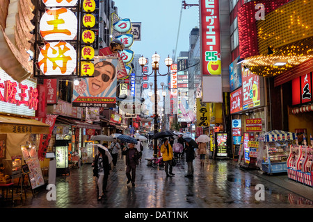 Die hellen Neonröhren von Dotonbori Restaurant und dem Einkaufsviertel entfernt an einem regnerischen Abend, Dotonbori, Osaka, Japan Stockfoto