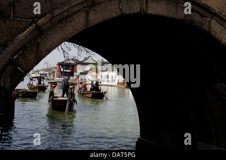 China, Stadtrand von Shanghai. Wasser Dorf Zhujiajiao. Ausflugsboote am Fluss Kanal mit alten Steinbrücke. Stockfoto