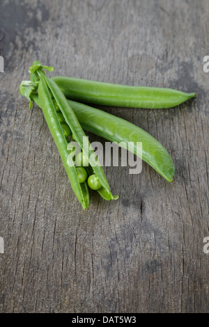 Haufen von frische Erbsenschoten auf Holztisch Stockfoto