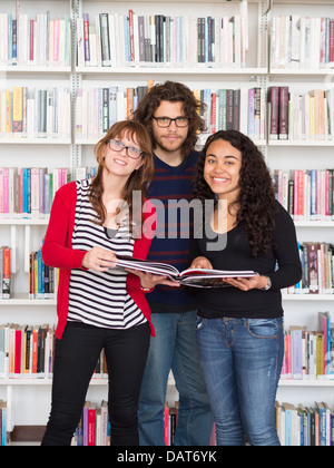 Multi ethnischen Gruppe von Menschen halten Buch in einer Bibliothek Stockfoto