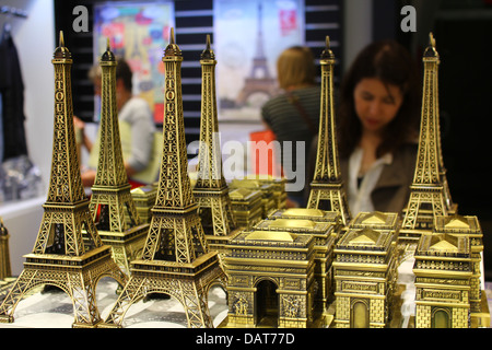 Tourist Shop innerhalb der Arc de Triomphe - Miniatur Eiffeltürme und Mini triumphal Bögen mit Menschen auf dem Hintergrund Stockfoto