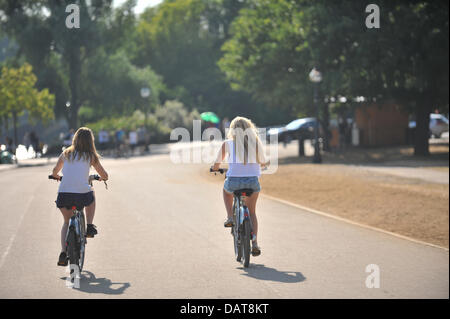 Hyde Park, London, UK. 18. Juli 2013. Zwei Mädchen auf dem Fahrrad in der Nähe der Serpentine in der Abendsonne. Bildnachweis: Matthew Chattle/Alamy Live-Nachrichten Stockfoto