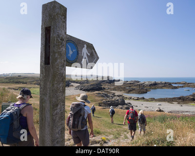 Wanderer zu Fuß durch öffentlichen Fußweg Wegweiser auf der Insel Anglesey Coastal Path von Porth-y-Garan Trearddur heilige Insel Anglesey Wales UK Stockfoto