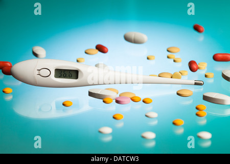 Thermometer zeigt gesunde Temperatur von 36,6 Grad mit vielen verschiedenen Drogen, Pillen und Tabletten in verschiedenen Formen und Form auf Blau lab Tabelle Stockfoto