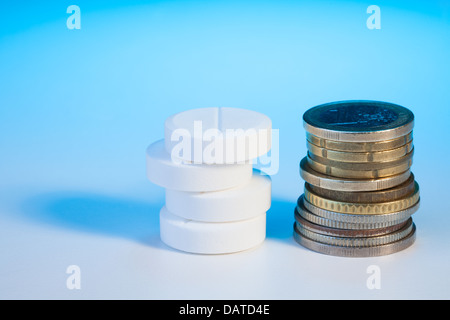 Pie des großen Kreises Tabletten Drogen auf blauer Tisch und Stapel von verschiedenen Euro-Münzen Stockfoto