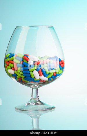 Medikament Pillen verschiedener Farbe in das Whiskyglas als Konzept des Trinkens Missbrauch Stockfoto