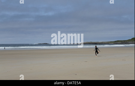 Junge mit Bodyboard läuft in Richtung Meer Machirs Bucht Isle of Islay Schottland Juli 2013 Stockfoto