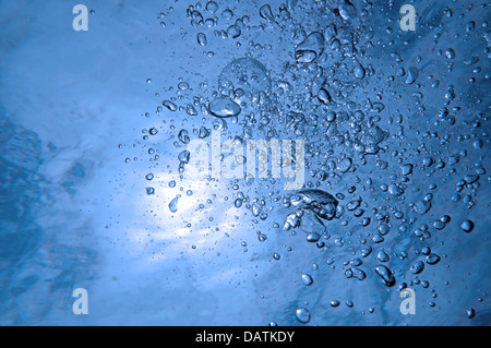 Luftblasen steigen an die Wasseroberfläche mit Sonnenlicht im Hintergrund, natürliche Szene Stockfoto