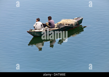 Zwei junge Burschen sitzen in kleinen Fischerboot mit Reflexion Stockfoto