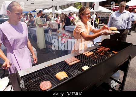 Amische Mädchen verkaufen Hamburger und Hot Dogs auf Bauernmarkt - Washington, DC USA Stockfoto