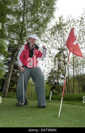 Eine junge Frau feiert auf dem Putt Golfplatz bei Route du Mazel, Kompetenz, Auvergne, haute - Loire, Frankreich Stockfoto