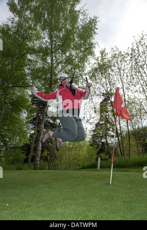 Eine junge Frau feiert auf dem Putt Golfplatz bei Route du Mazel, Kompetenz, Auvergne, haute - Loire, Frankreich Stockfoto