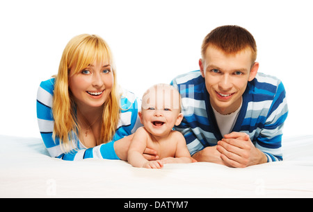 Niedlichen kleinen Jungen Lachen verlegen mit den Eltern im Bett Stockfoto