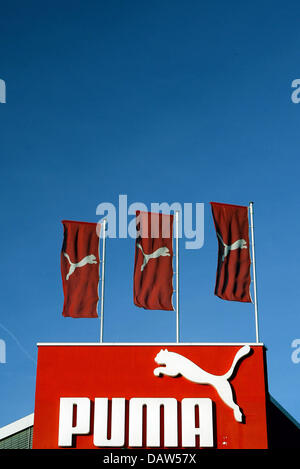 PUMA Unternehmen Logo und drei roten Fahnen mit dem weißen Logo gezeigt auf dem Dach des Outlet-Store des Unternehmens vor einem strahlend blauen Himmel in Herzogenaurach, Deutschland, Freitag, 16. Februar 2007. Foto: Daniel Karmann Stockfoto