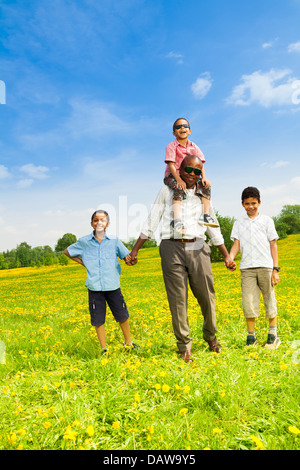Glücklicher Vater mit Söhnen und ihn auf seinen Schultern stehend Stockfoto