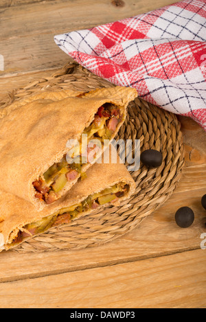 Frische hausgemachte Calzone halbieren zeigt seine Füllung Stockfoto