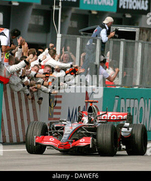 Spanische Formel1 Piloten Fernando Alonso von McLaren Mercedes fährt vorbei an das Mechaniker-Team am Ende des Grand Prix von Malaysia in Sepang Circuit in der Nähe von Kuala Lumpur, Malaysia, Sonntag, 8. April 2007. Foto: JENS BÜTTNER Stockfoto