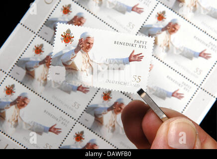 Das Bild zeigt eine Hand, die eine besondere Briefmarken mit dem Bild von Papst Benedict XVI mit einer Pinzette in Straubing, Deutschland, Donnerstag, 12. April 2007. Die Deutsche Post begonnen, den Stempel für 55 Cent bieten nur vier Tage vor Papst Benedict XVI feiert seinen 80. Geburtstag kommenden Montag, den 16. April. Aufgrund der erwarteten hohen Nachfrage produziert der Deutschen Post mehr als 10 mil Stockfoto