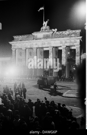 Geographie / Reisen, Deutschland, Wiedervereinigung, Berlin, Berliner Mauer, DDR-Grenztruppen kontrollieren das Brandenburger Tor mit Wasserwagen, Nachtaufnahme, 10. / 11.11.1989, DDR, historisch, historisch, Ostdeutschland, 20. Jahrhundert, 1980er, 80er Jahre, Pariser Platz, Brandenburger Tor, Platz, Feier, Menschen, Feiern, 24 Stunden nach dem Sturz, unten, Eröffnung, Wendung der Ereignisse, Geschichte, Freiheit, Überfahrt, November'89, November 89, Grenzpatrouille, Zusatz-Rechteklärung-nicht vorhanden Stockfoto