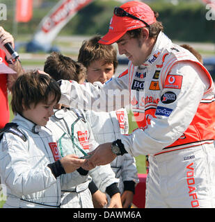 Spanisch-Formel-1-Fahrer Fernando Alonso von McLaren Mercedes übergibt eine junge Kartfahrer Gewinn der "Vodafone Spanien Kart Challenge" auf der Rennstrecke Circuit de Catalunya in der Nähe von Barcelona, Spanien, 10. Mai 2007 eine Trophäe. Foto: CARMEN JASPERSEN Stockfoto