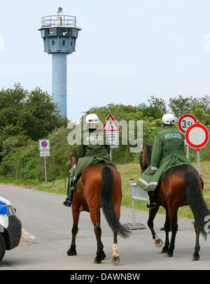 Montiert Polizisten patrouillieren vor einem ehemaligen Wachturm der Deutschen Demokratischen Republik (DDR) in Boergerende, Deutschland, 30. Mai 2007. Der Wachturm dient zur Polizei Abdeckung des G8-Gipfels. Die G8-Sicherheitszaun sperrt die Öffentlichkeit aus dem G8-Gipfel Heiligendamm vom 6. bis 8. Juni 2007 laufen. Zufahrten dürfen nur durch autorisierte Personen weitergegeben werden, nach se Stockfoto