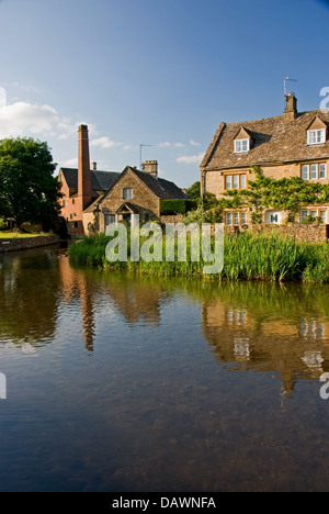 Hütten und die alte Wassermühle in Lower Slaughter, spiegelt sich in den Fluss Auge im Cotswold Village. Stockfoto