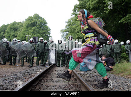 Eine verkleidete Demonstrant übergibt Gleisanlagen vor Polizisten schützen den Sicherheitszaun in Heiligendamm, Deutschland, 6. Juni 2007. Tausende von DemonstrantInnen kamen für Proteste am Zaun. Der G8-Gipfel wird unter intensiven Sicherheitsmaßnahmen vom 6. bis 8. Juni in Heiligendamm stattfinden. Foto: Rainer Jensen Stockfoto