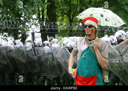 Eine verkleidete Demonstrant steht vor den Polizisten schützen den Sicherheitszaun in Vorder Bollhagen, Deutschland, 6. Juni 2007. Tausende von DemonstrantInnen kamen für Proteste am Zaun. Der G8-Gipfel wird unter intensiven Sicherheitsmaßnahmen vom 6. bis 8. Juni in Heiligendamm stattfinden. Foto: Bodo Marks Stockfoto