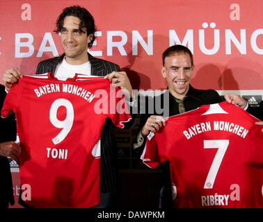 Bundesliga-Verein Bayern des neuen unterzeichnet französischen internationalen Franck Ribery (2-R) und italienischen Stürmer Luca Toni (2 L) Lächeln mit ihren neuen Trikots und Bayern München Finanzvorstand Karl Hopfner (L) und Münchner general Manager Uli Hoeness (R) bei ihrer offiziellen Präsentation in München, 7. Juni 2007. Foto: Matthias Schrader Stockfoto