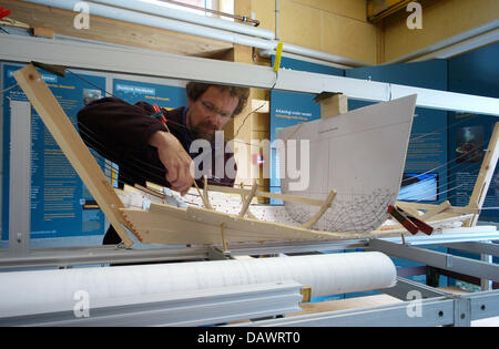 Ein Besucher wirft einen Blick auf ein Modell eines Wikingerschiffes in der archäologischen Werkstatt des Museums für Wikingerschiffe in Roskilde, Dänemark, 22. Mai 2007. Das Modell stellt das ehrgeizigste Projekt der Wikinger Schiff der Welt. Das lange Boot Skuldelev 2, ein Wikinger Kriegsschiff mit 30 Meter Länge, wird derzeit mit Werkzeugen aus der Wikingerzeit rekonstruiert. Am 1. Juli 2007 wird es