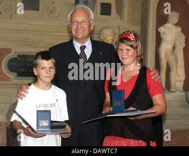 Siblings Kira (R) und Leon (L) Heuer Lächeln mit Bavarian Prime Minister Edmund Stoiber (C) nach Erhalt der Christophorus-Medaille in München, Deutschland, 15. Juni 2007. Beide erhalten d die Medaille für Rescueing einen jungen, der mit schweren Herzproblemen im Jahr 2005 brach zusammen. Foto: Frank Maechler Stockfoto