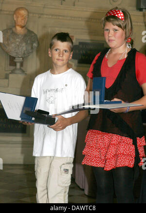 Siblings Kira (R) und Leon (L) Heuer Lächeln nach dem Erhalt der Christophorus-Medaille in München, Deutschland, 15. Juni 2007. Beide erhielt die Medaille aus den Händen von Bayerns Ministerpräsident Edmund Stoiber für die Rettung eines jungen, der mit schweren Herzproblemen im Jahr 2005 brach zusammen. Foto: Frank Maechler Stockfoto