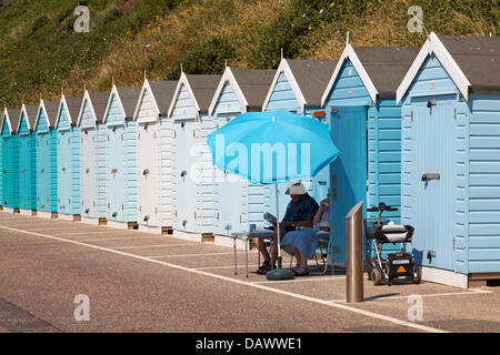 Bournemouth, UK 19. Juli 2013. Hitzewelle weiterhin als Sonnenanbeter Kopf nach Bournemouth. Älteres Ehepaar genießen eine Tasse Kaffee im Schatten des Sonnenschirms außerhalb einer Strandhütte auf Promenade zwischen Bournemouth Pier und Boscombe. Bildnachweis: Carolyn Jenkins/Alamy Live-Nachrichten Stockfoto