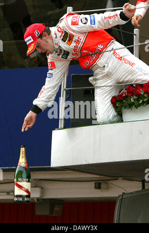 Dritte platzierte spanische Formel1 Piloten Fernando Alonso von McLaren Mercedes wirft die Flasche Champagner zu seinem Team vom Podium, nachdem beim spanischen Grand Prix Circuit de Catalunya Rennen verfolgen in Montmelo in der Nähe von Barcelona, Spanien, Sonntag, 13. Mai 2007. Foto: JENS Büttner Stockfoto