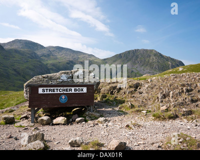 Mountain Rescue Bahre Box an Sty Spitze, überragt von Scafell Pike und Lingmell in The Lake District, Cumbria Stockfoto