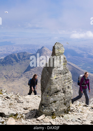 Zwei Frauen Wanderer Wandern in der Nähe von Stein Marker an Spitze der Watkin Pfad auf Snowdon Südgrat mit Y Lliwedd in Snowdon Hufeisen. Snowdonia Wales UK Stockfoto