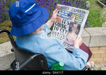 90 Jahre alte Frau liest Daily Express mit der Titelseite "Es wird heißer". Globale Erwärmung, Klimawandel. Stockfoto