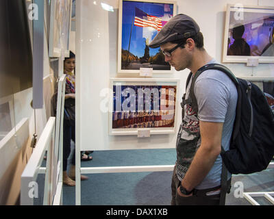 19. Juli 2013 schaut Fotos hängen in einer Ausstellung in CentralWorld in Bangkok - Bangkok, Thailand - A Tourist. Die US-Botschaft in Bangkok sponserte die Fotoausstellung, die feiert 180 Jahre US-thailändische diplomatische Beziehungen. Es gibt 180 Fotos hängen in der Show, 90 von amerikanischen Fotografen in Thailand und 90 von Thai Fotografen in den Vereinigten Staaten. Die Show, die 19 Juli eröffnete hängt im CentralWorld, ein großes Einkaufszentrum in Bangkok, und tourt Thailand, wenn es seine Bangkok laufen am 21. Juli abgeschlossen. (Bild Kredit: Jack Kurtz/ZUMAPRESS.com ©) Stockfoto