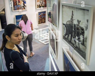 19. Juli 2013 weisen über Thai-amerikanischen Beziehungen in CentralWorld in Bangkok - Bangkok, Thailand - A Thai Fotos hängen bei einem Foto Frau anschaut. Die US-Botschaft in Bangkok sponserte die Fotoausstellung, die feiert 180 Jahre US-thailändische diplomatische Beziehungen. Es gibt 180 Fotos hängen in der Show, 90 von amerikanischen Fotografen in Thailand und 90 von Thai Fotografen in den Vereinigten Staaten. Die Show, die 19 Juli eröffnete hängt im CentralWorld, ein großes Einkaufszentrum in Bangkok, und tourt Thailand, wenn es seine Bangkok laufen am 21. Juli abgeschlossen. (Bild Kredit: Jack Kurtz/ZUMAPRESS.com ©) Stockfoto