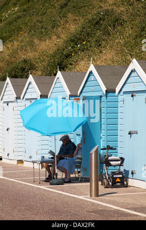 Bournemouth, UK 19. Juli 2013. Hitzewelle weiterhin als Sonnenanbeter Kopf nach Bournemouth. Älteres Ehepaar genießen eine Tasse Kaffee im Schatten des Sonnenschirms außerhalb einer Strandhütte auf Promenade zwischen Bournemouth Pier und Boscombe. Bildnachweis: Carolyn Jenkins/Alamy Live-Nachrichten Stockfoto