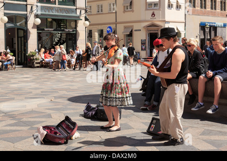 Straßenmusikanten spielen unterhaltsame Musik in Amagertorv Platz besetzt mit einem Publikum Menschen ansehen und anhören. Amager Torv, Kopenhagen, Dänemark Stockfoto