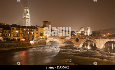 Verona - Pietra Brücke in der Nacht - Ponte Pietra und Dom-Turm und Kirche von San Giorgio im Hintergrund Stockfoto