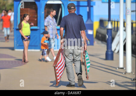 BARRY ISLAND, VEREINIGTES KÖNIGREICH. 19. Juli 2013. Die britische Hitzewelle weiter und die Menschen strömen zu den Stränden in Süd-Wales. Ein Mann trägt liegen entlang der Promenade. Foto Credit: Polly Thomas / Alamy Live News Stockfoto