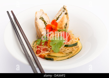 Asiatische Küche mit Stück gefüllte Hähnchen, Nudeln, Zucchini, Karotten und Tomaten. Stockfoto