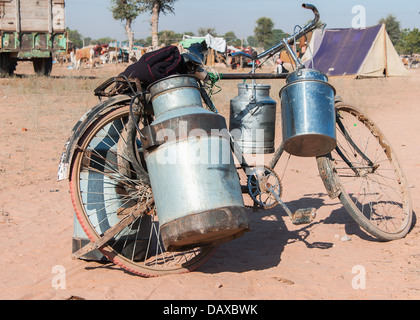 Fahrrad mit Milch Kanister auf seiner Seite am Nagaurs Viehmarkt in Rajasthan. Stockfoto