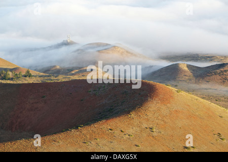 Wolken über Schlackenkegel an den Flanken des ruhenden Vulkans Mauna Kea auf der Big Island von Hawaii fließt. Stockfoto